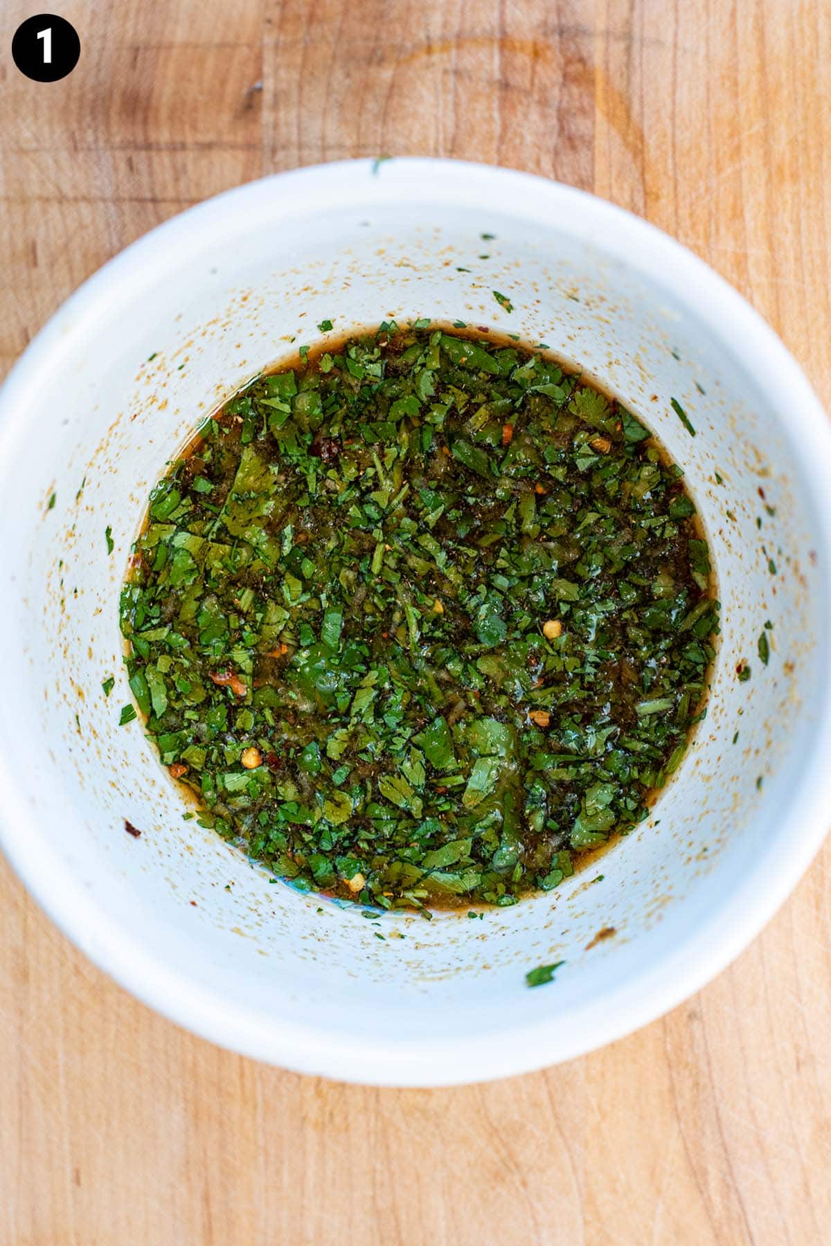 Fresh cilantro lime marinade ingredients mixed in a small white bowl.