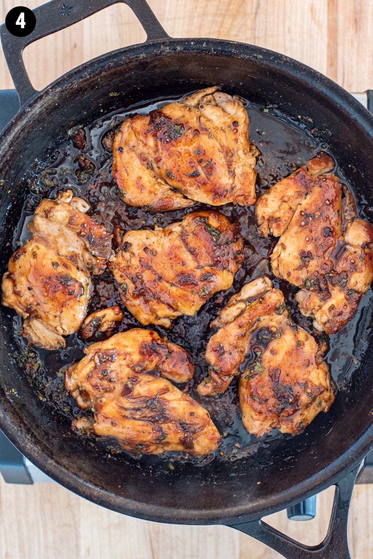 Golden cilantro lime chicken covered in a caramelized glaze in a cast iron skillet.