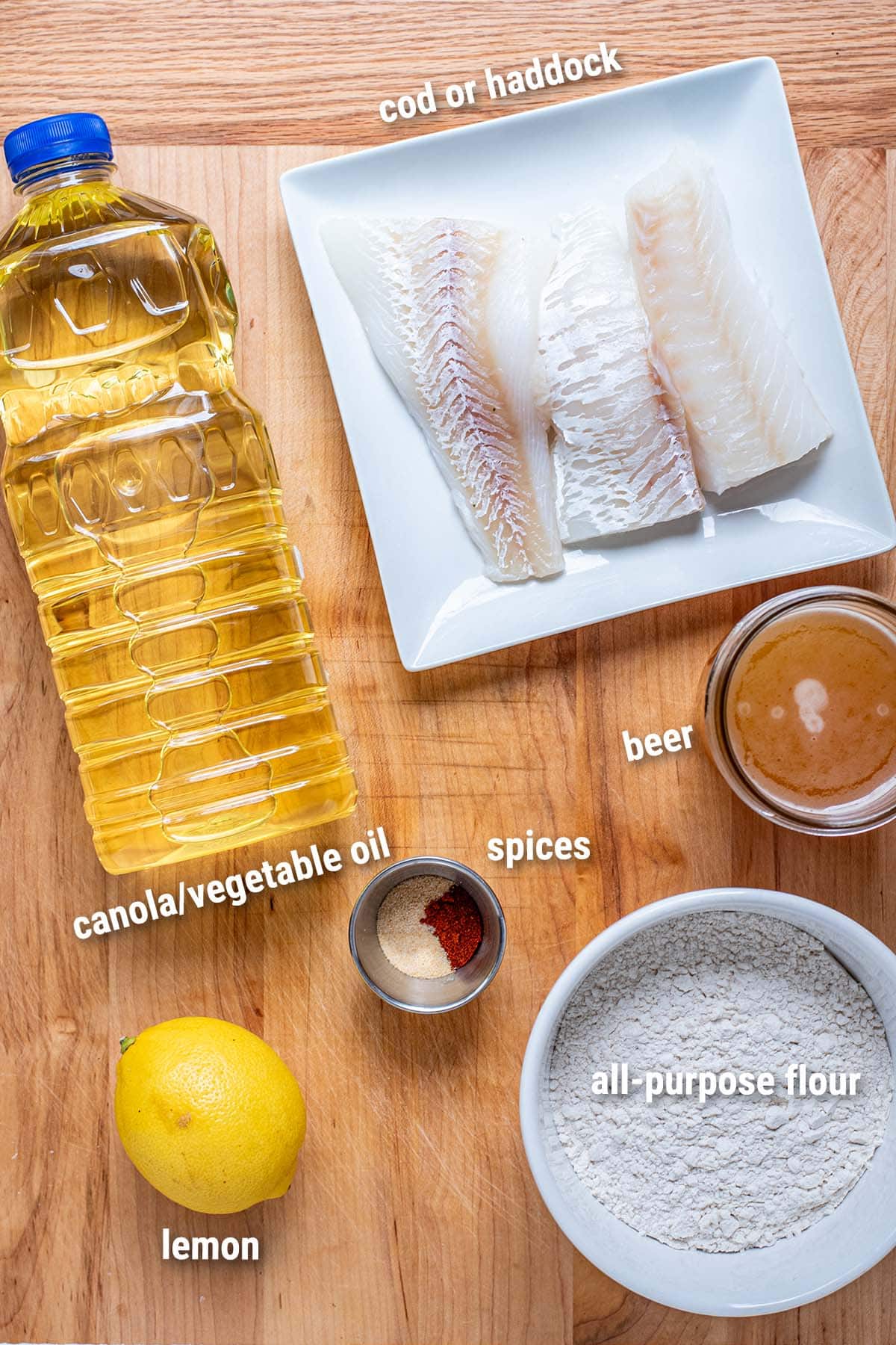 Raw, uncooked beer-battered fish ingredients laid out on a wooden cutting board.