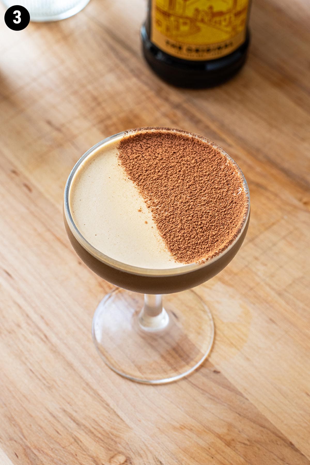 A chocolate espresso martini topped with a dusting of cocoa powder.