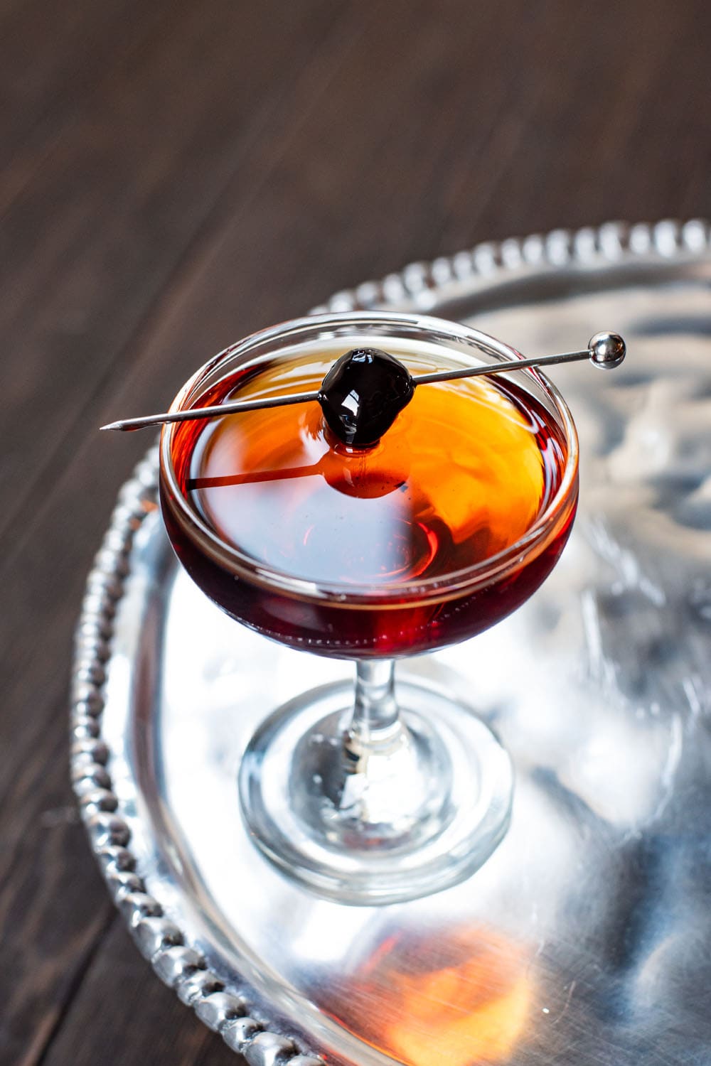 Manhattan cocktail served in a coupe glass with a brandied cherry.