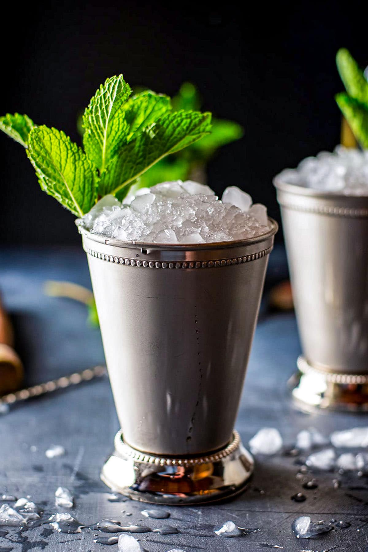 A Mint Julep cocktail topped with crushed ice and garnished with a fresh mint sprig.