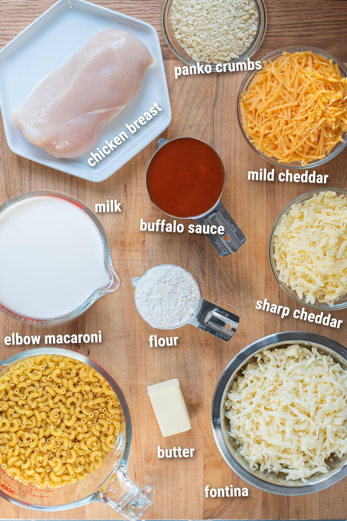 Raw/uncooked buffalo chicken mac and cheese ingredients laid out on a cutting board.