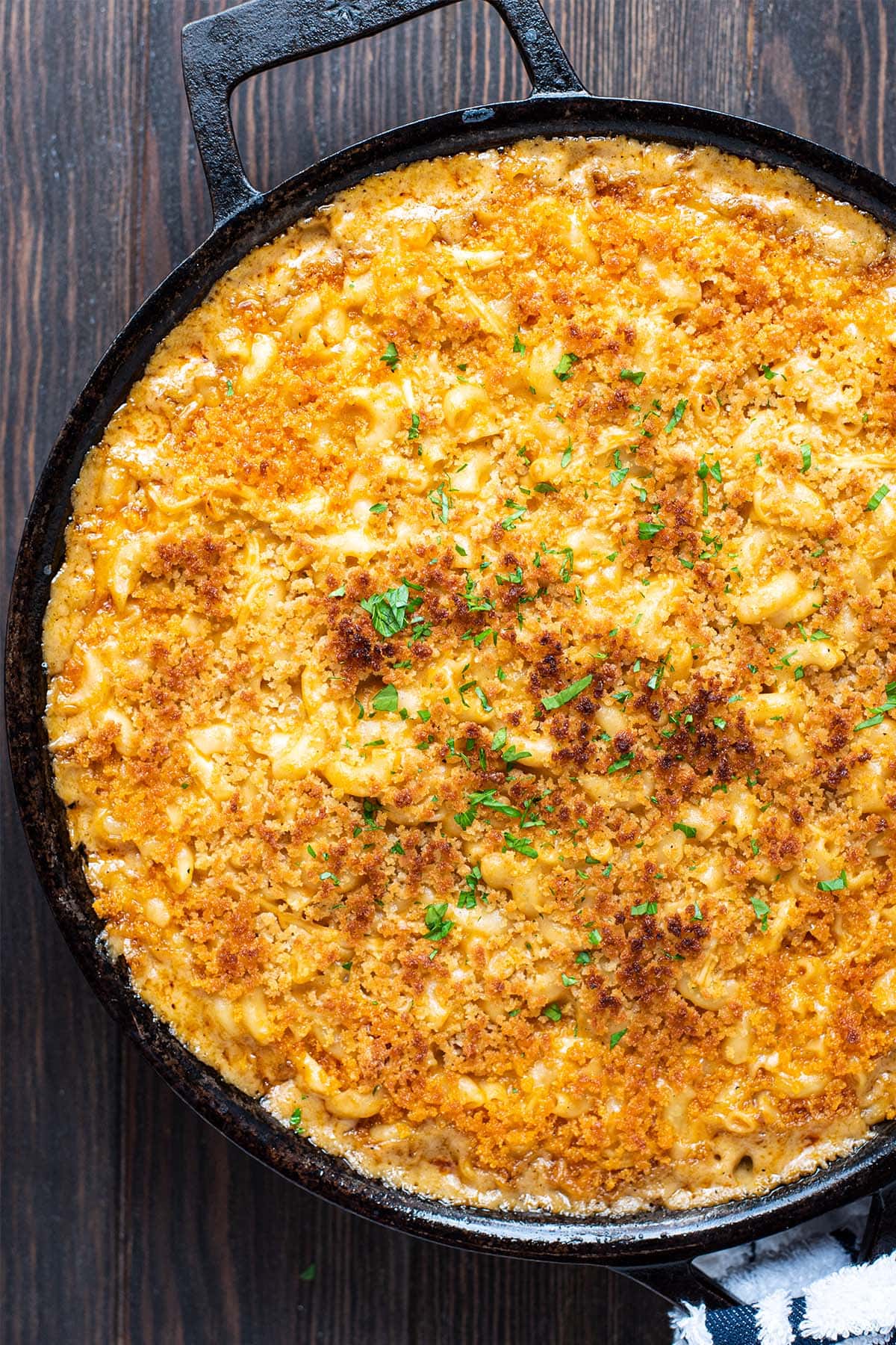 Golden baked buffalo chicken mac and cheese in a cast iron skillet.