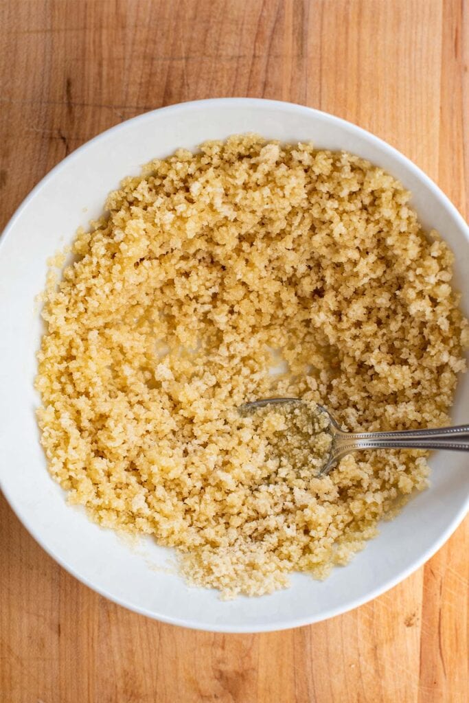 Melted butter and golden panko crumbs in a small white bowl.