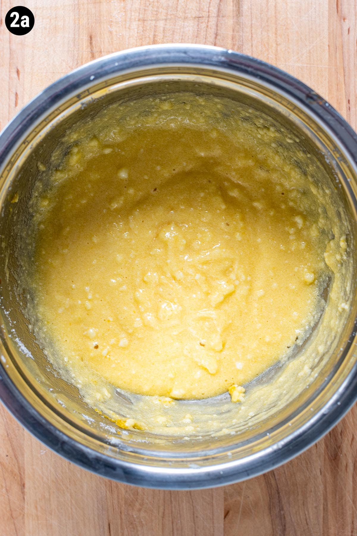 Blueberry muffin batter made with egg, sugar, and butter.