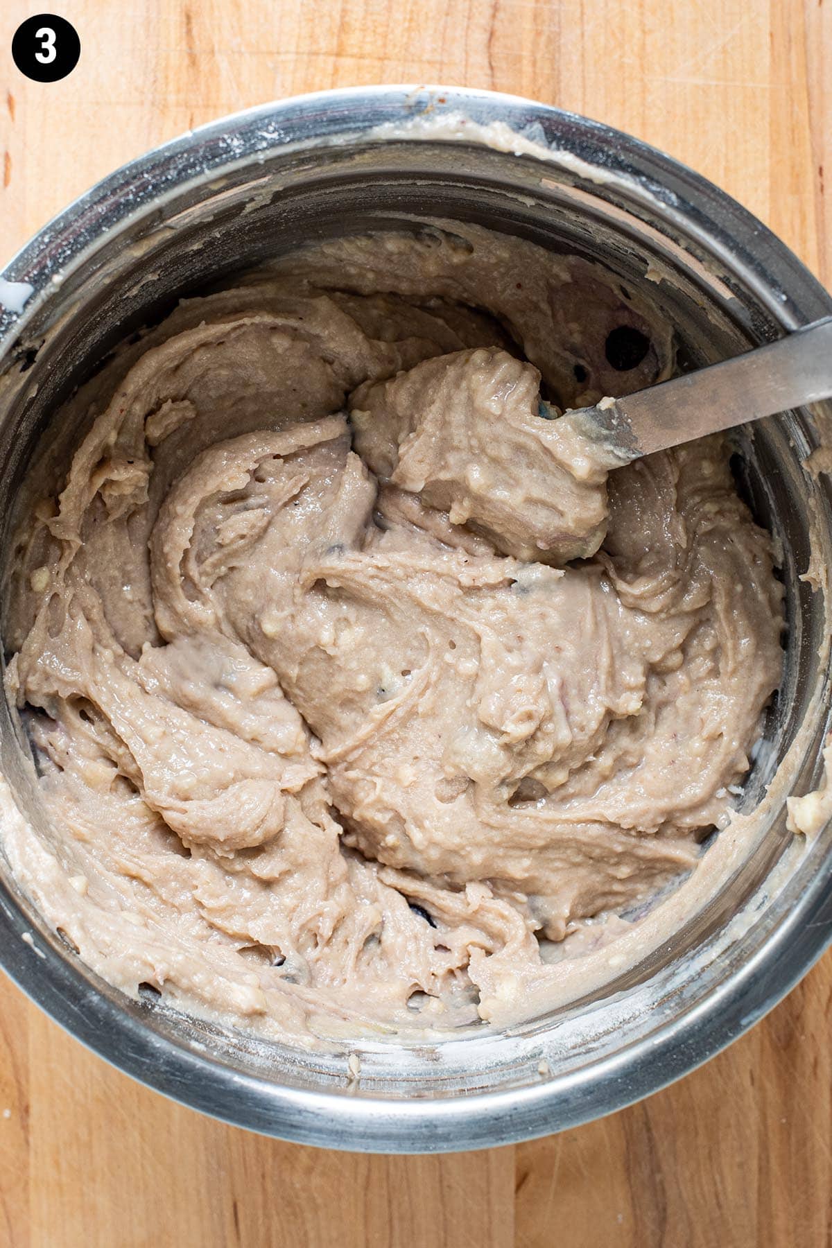 Blueberry muffin batter in a stainless steel bowl.