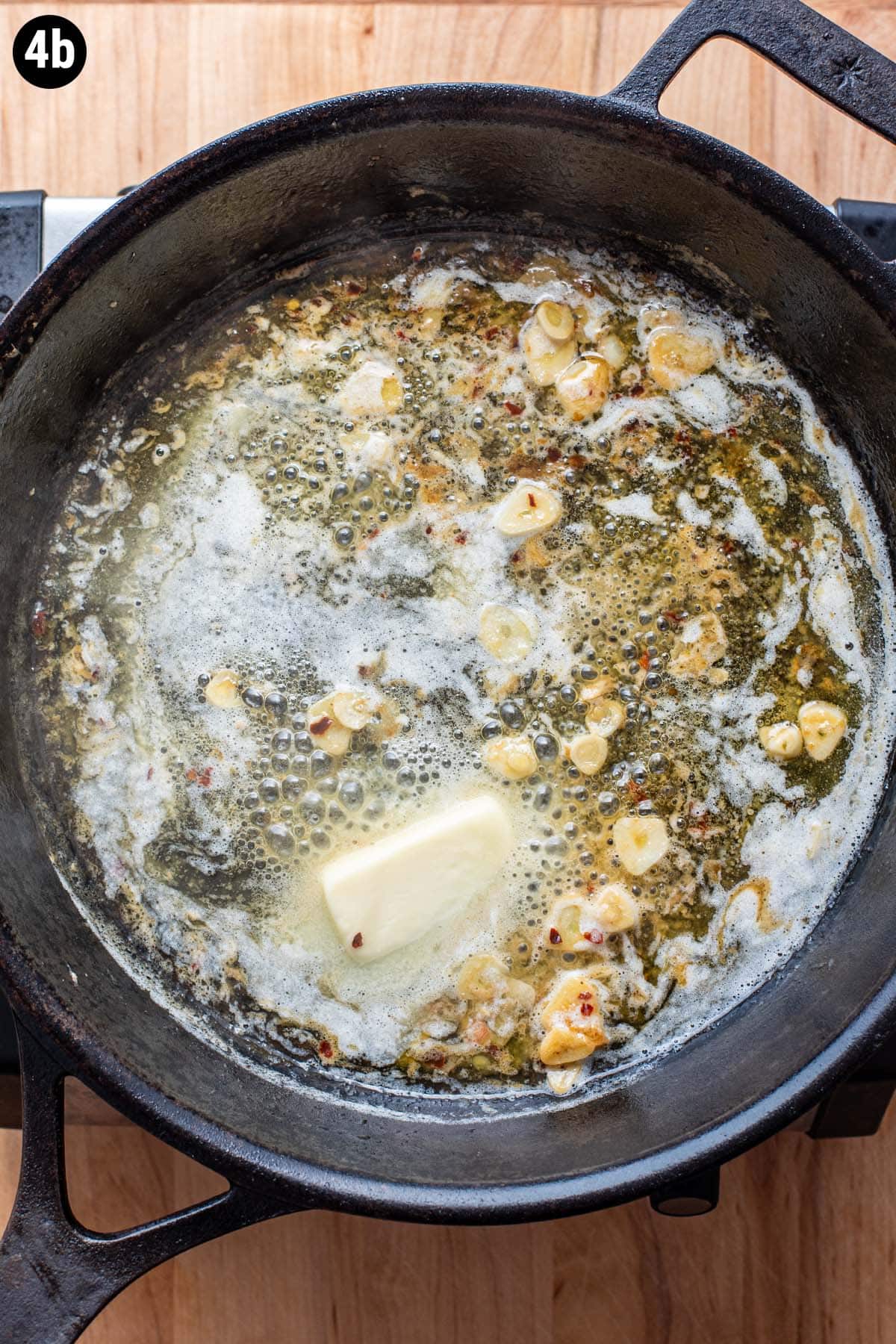 Butter, garlic and wine simmering in a cast iron skillet.