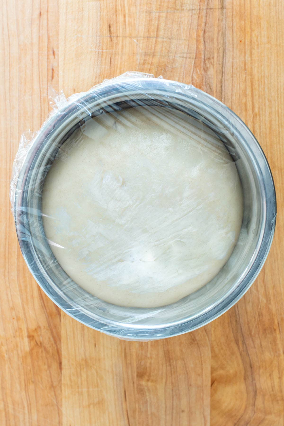 Room temp pizza dough that has risen in a stainless steel bowl.