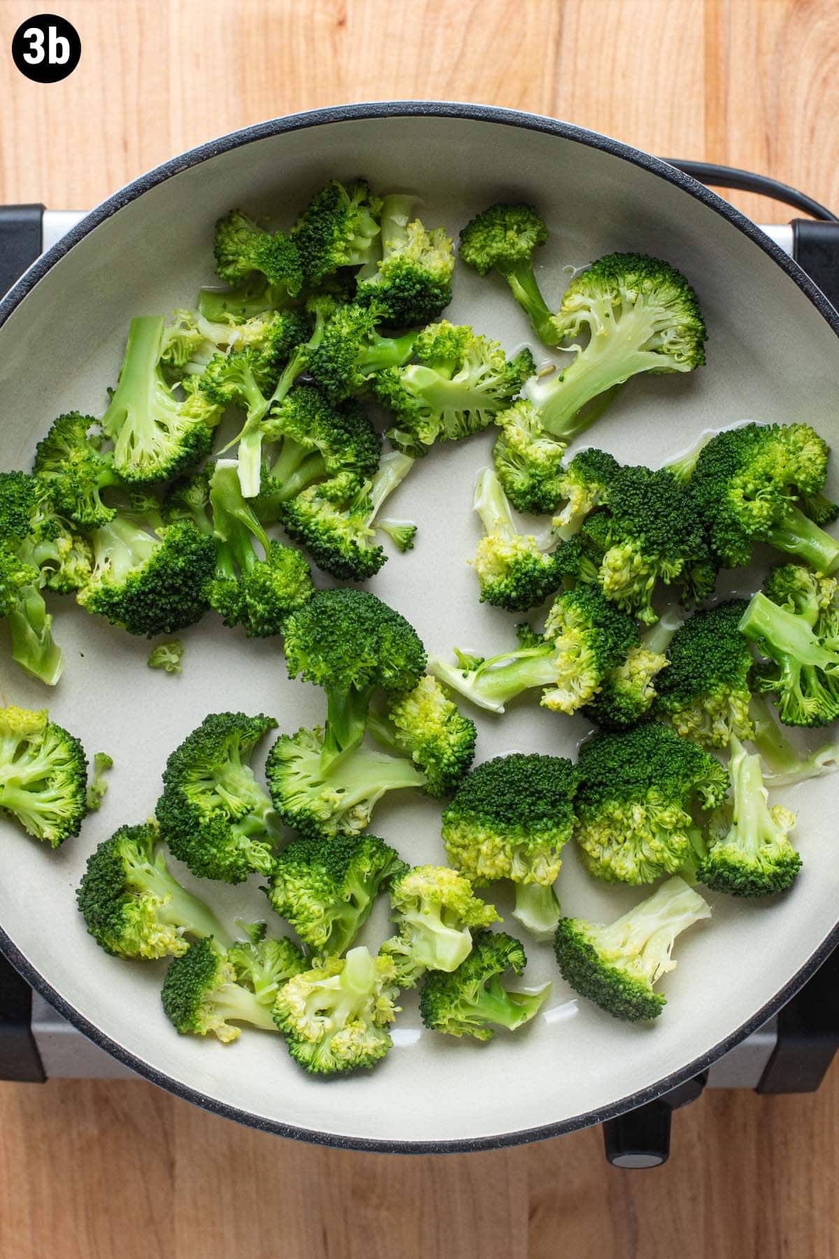 Steamed broccoli in a pan after it's finished cooking.