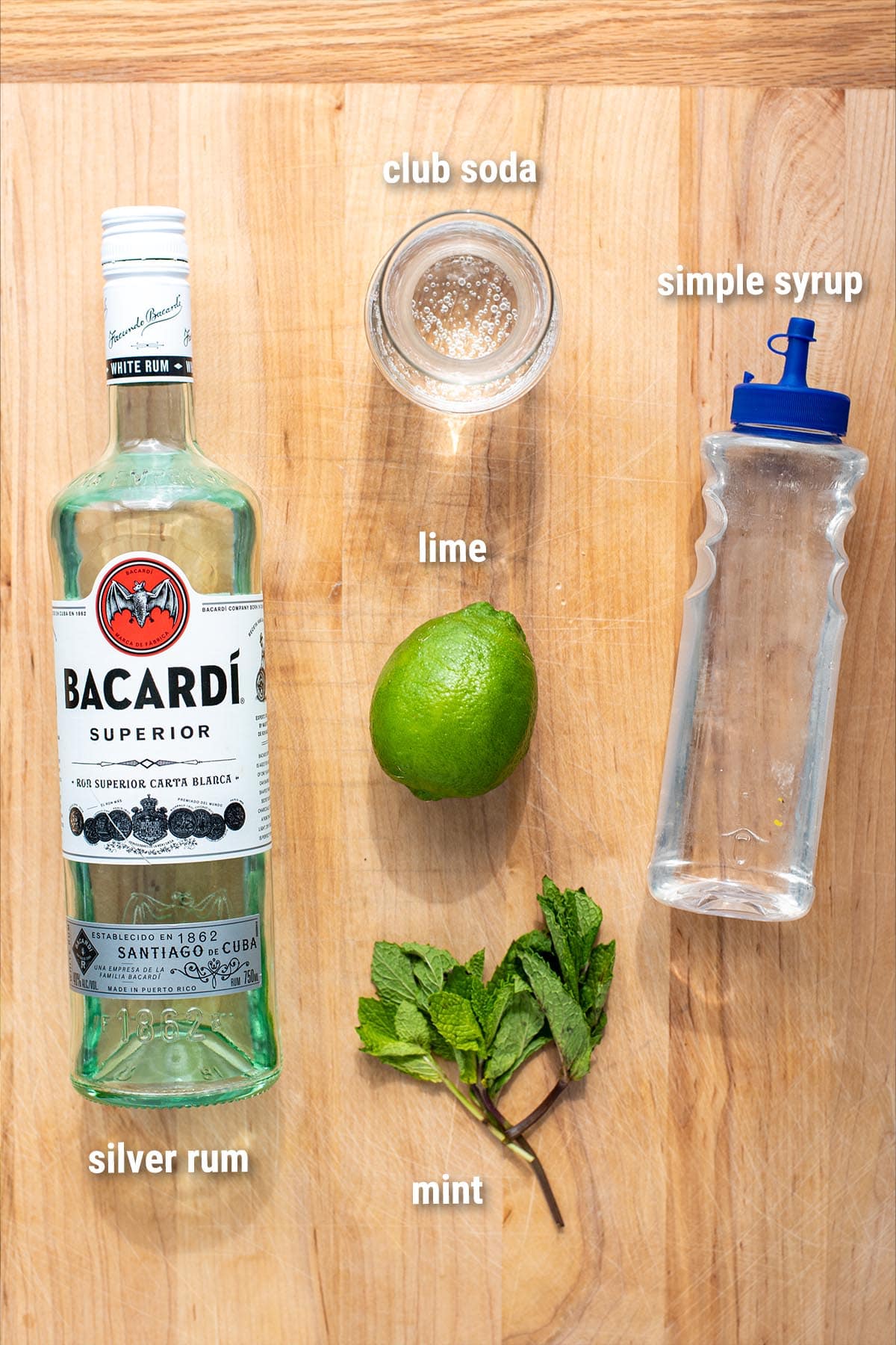 Classic mojito ingredients laid out on a wooden cutting board.