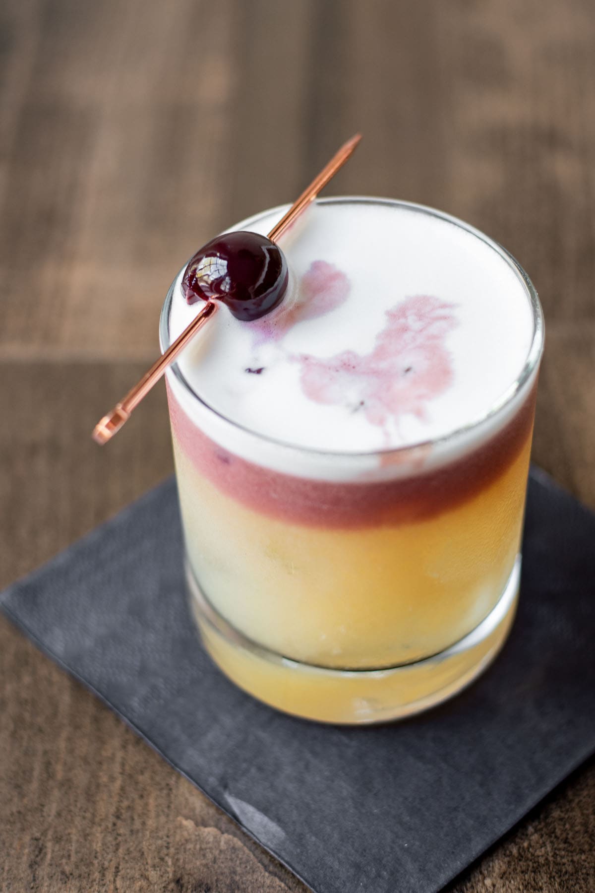 A New York Sour cocktail on a wooden table.