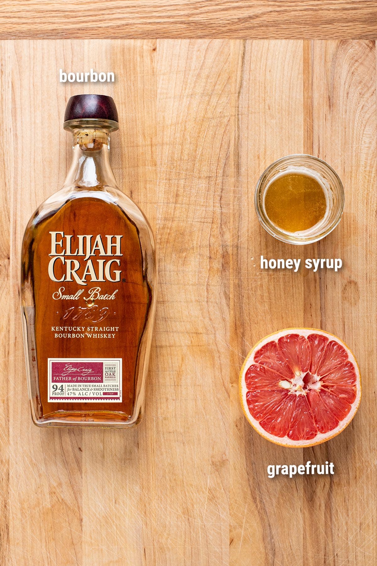 Brown Derby cocktail ingredients laid out on a wooden cutting board.