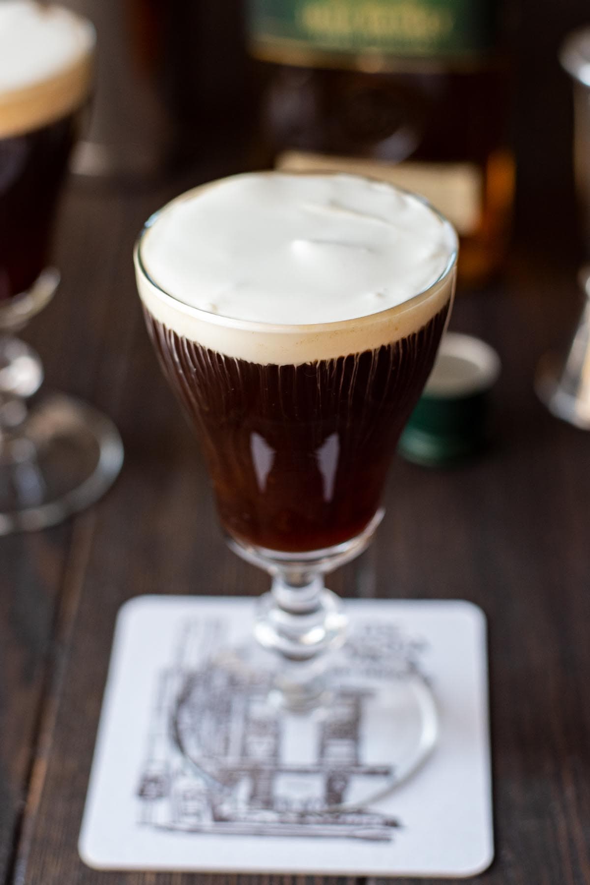 An Irish coffee cocktail topped with a collar of lightly whipped cream.