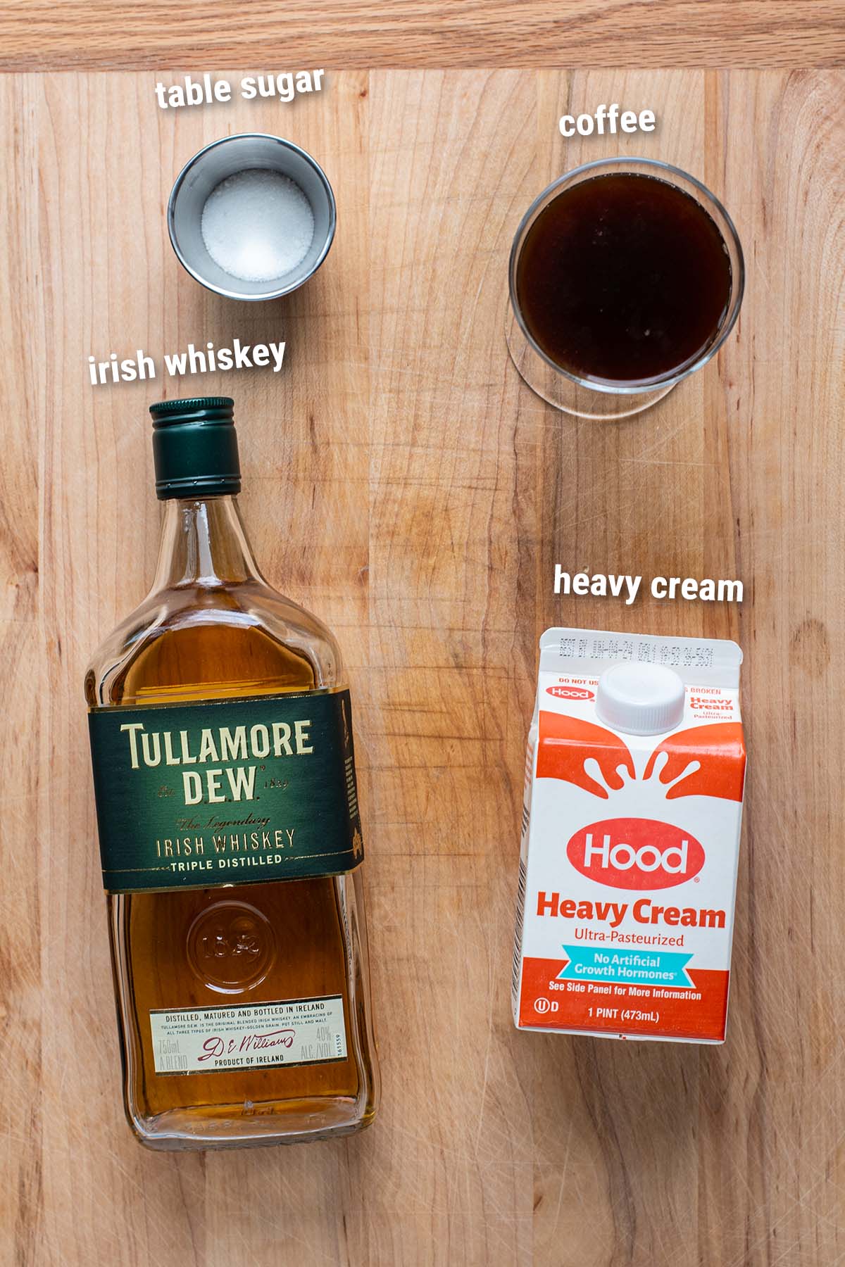 Irish Coffee ingredients laid out on a wooden cutting board.