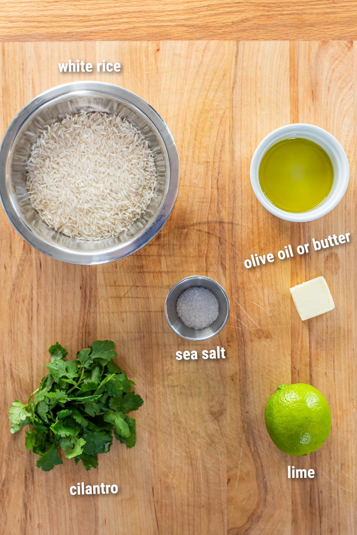 Raw, uncooked cilantro lime rice ingredients laid out on a cutting board.
