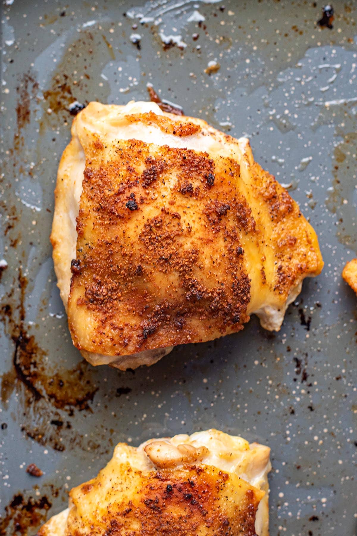 A golden crispy roasted chicken thigh topped with dry spices.