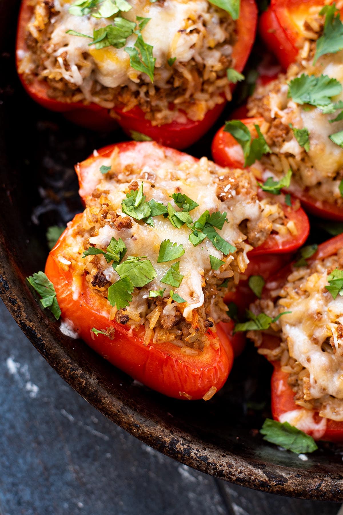 Ground turkey stuffed peppers topped with melted cheese and chopped fresh cilantro.