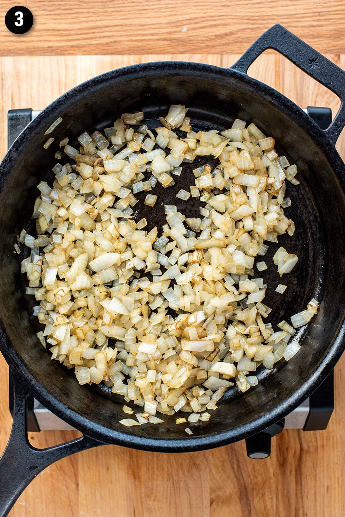 Chopped onions cooking in a cast iron skillet
