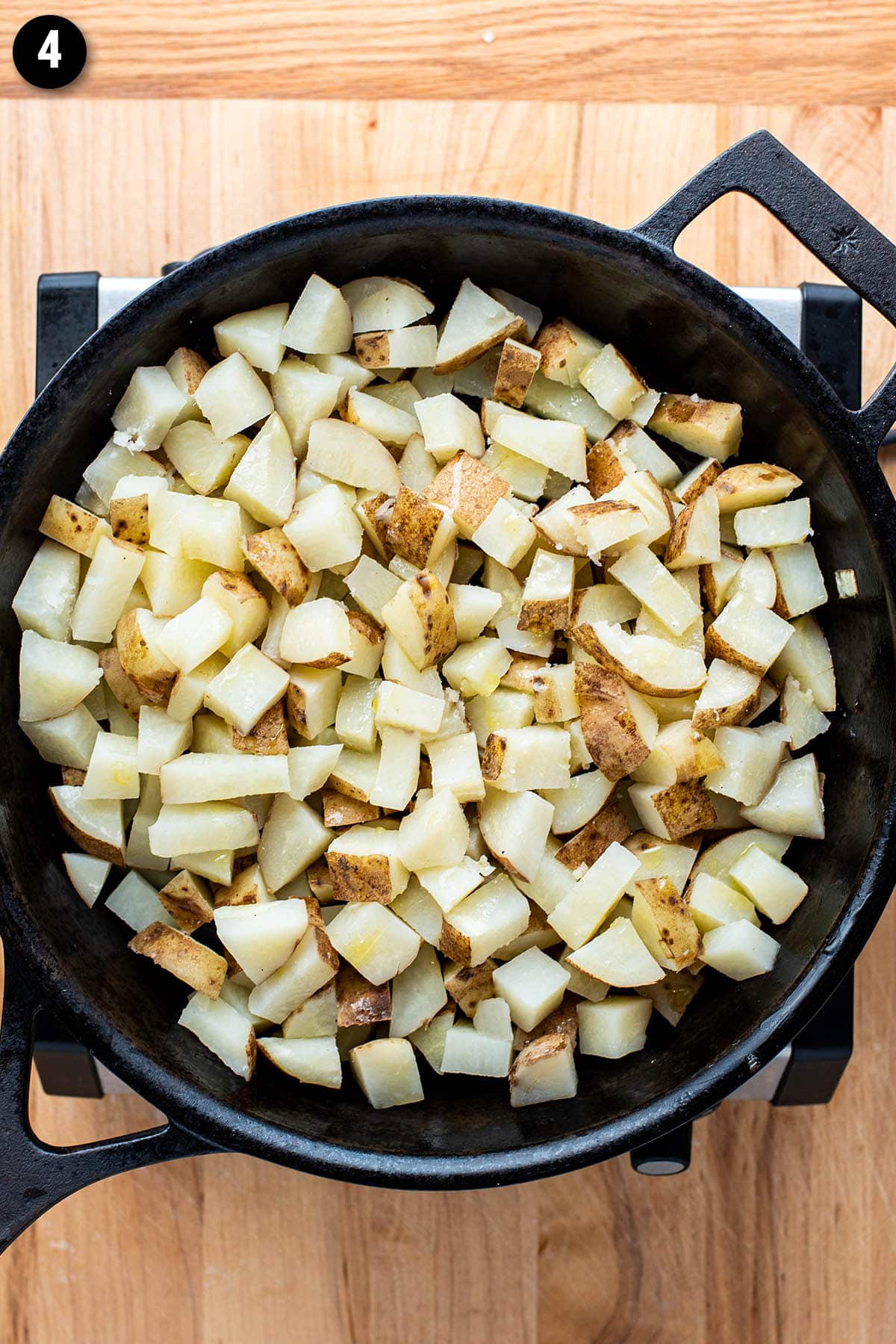 Par boiled chopped russet potatoes in a cast iron skillet before cooking.