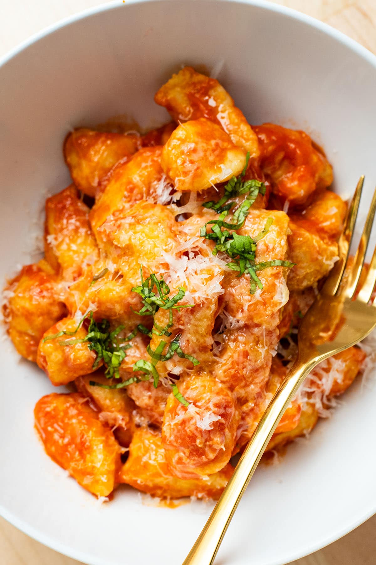 Potato gnocchi served with tomato sauce and topped with fresh grated parmesan and chipped basil.