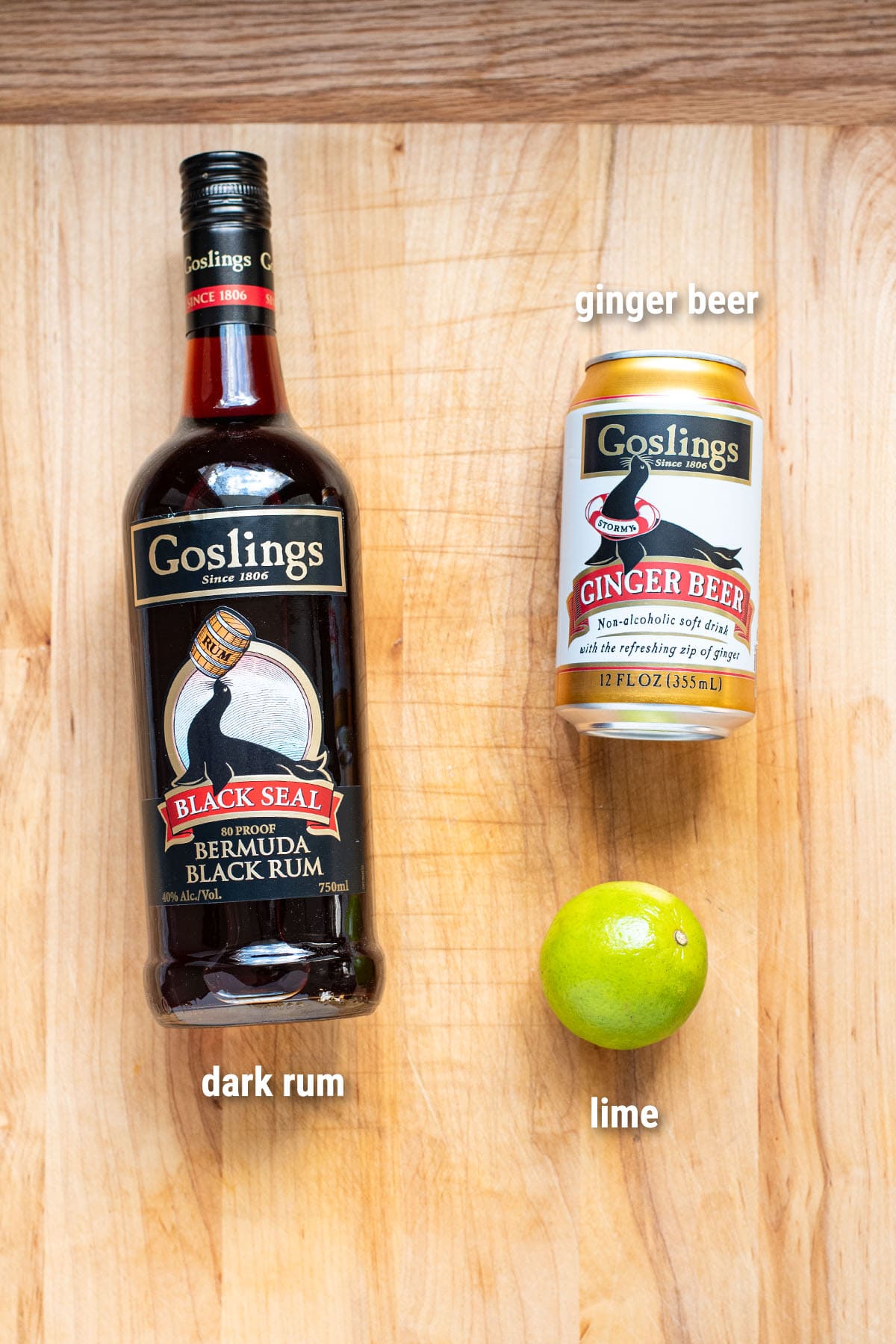 Dark 'n Stormy cocktail ingredients laid out on a wooden cutting board.