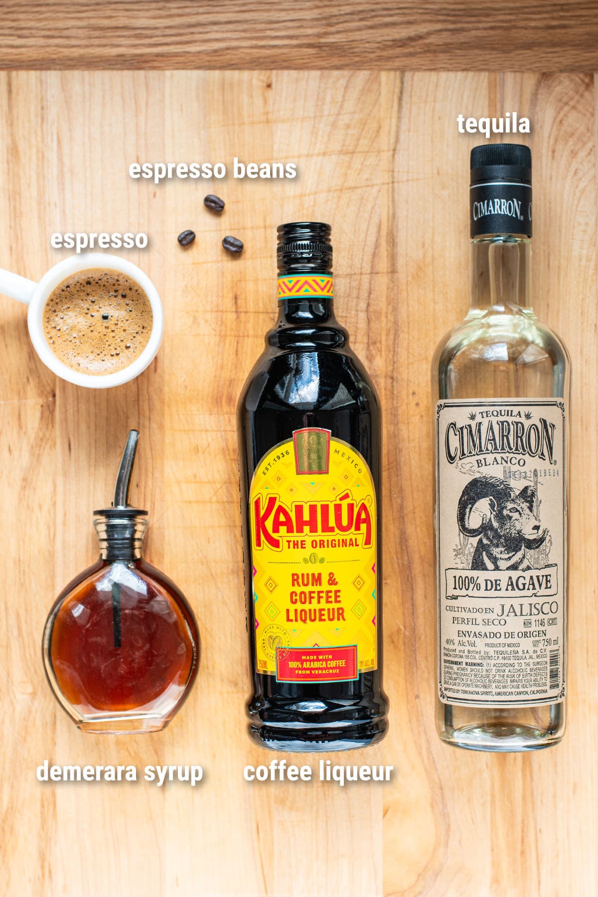 Ingredients to make a Tequila Espresso Martini laid out on a wooden cutting board.