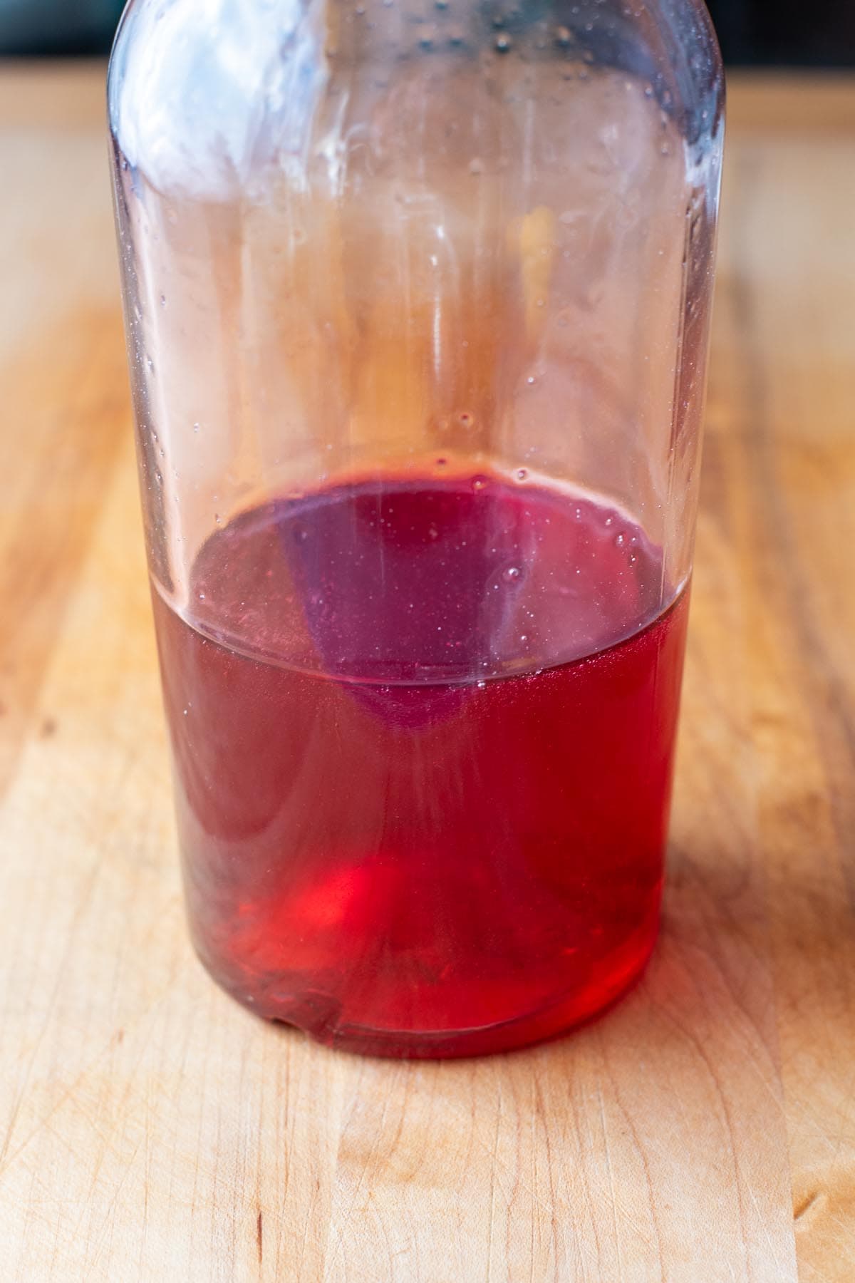 Raspberry simple syrup for cocktails in a glass jar.